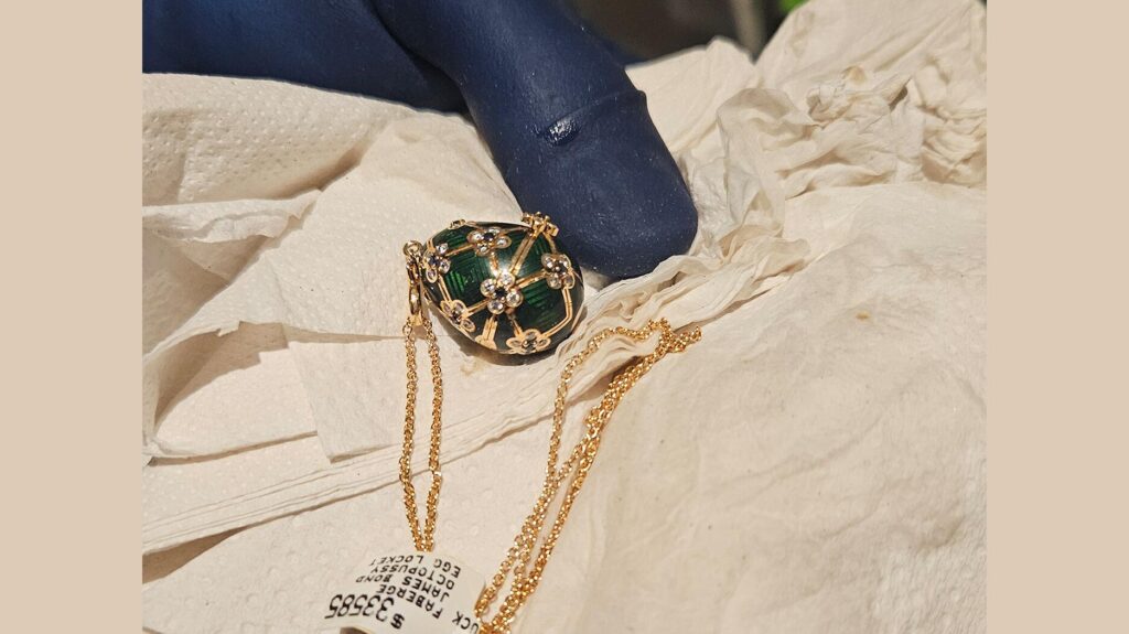 Fabergé egg pendant near gloved hand