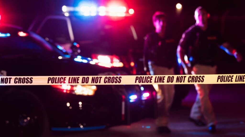 Stock image of crime scene with police cars and crime scene tape