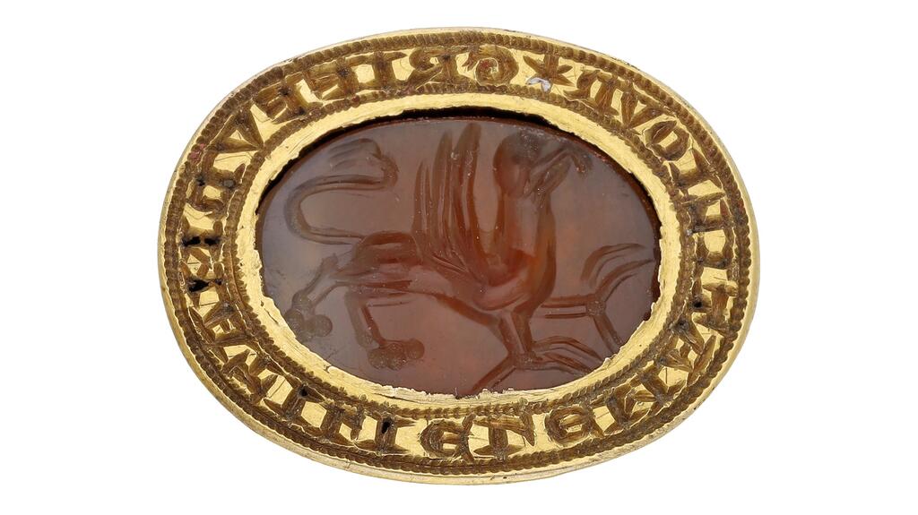 La bague présente une intaille en cornaline médiévale gravée de l'image d'un griffon et une lunette ovale en or avec une inscription en écriture lombarde. Bague sceau médiévale en or de Mathilde